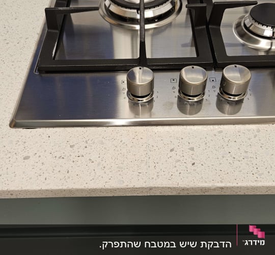 משטח שיש בהיר ליד כיריים גז